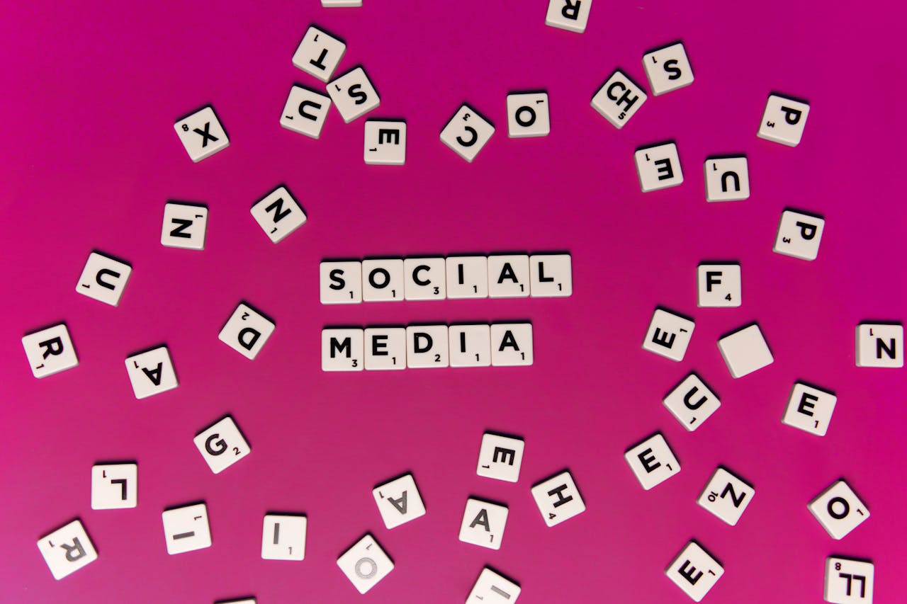 Alphabet tiles forming Social Media on a vibrant pink background, perfect for digital marketing themes.